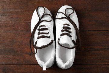 Pair of stylish shoes with laces on wooden background, flat lay
