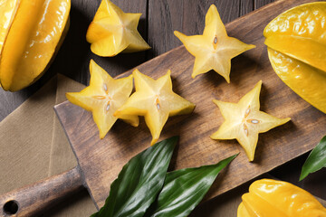 Delicious carambola fruits on wooden table, flat lay