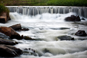 Fototapeta na wymiar Small waterfall full of rocks in a river in the brazilian countryside.