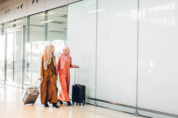 Two young asian muslim woman enjoying shopping and having fun talking together in the shop at...