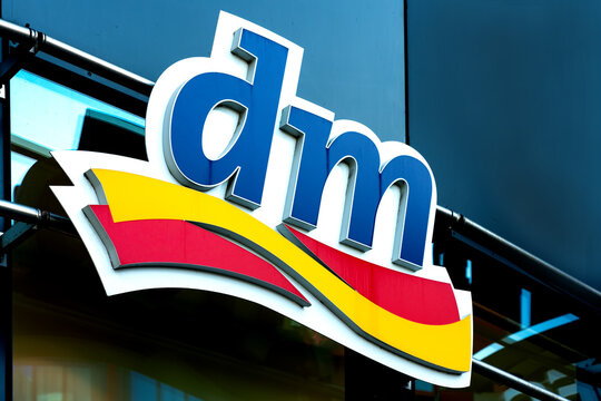 dm logo on a wall. dm-drogerie markt is a chain of retail stores that sells cosmetics, healthcare items, household products and health food