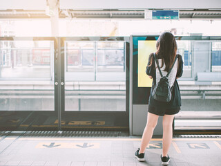 City life concept from Asian young woman waiting for electric train in Bangkok, Thailand