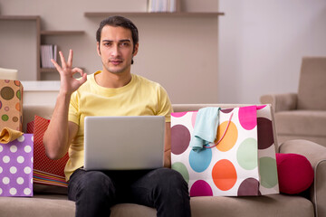 Young man ordering giftboxes via Internet