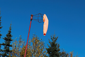 A windsock hangs calmly against a blue sky