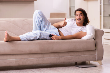 Young lazy man in oversleeping concept at home