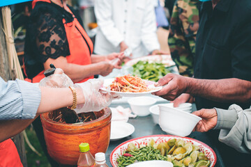 Volunteers donating food to people in a society in need of food: the concept of helping with food.