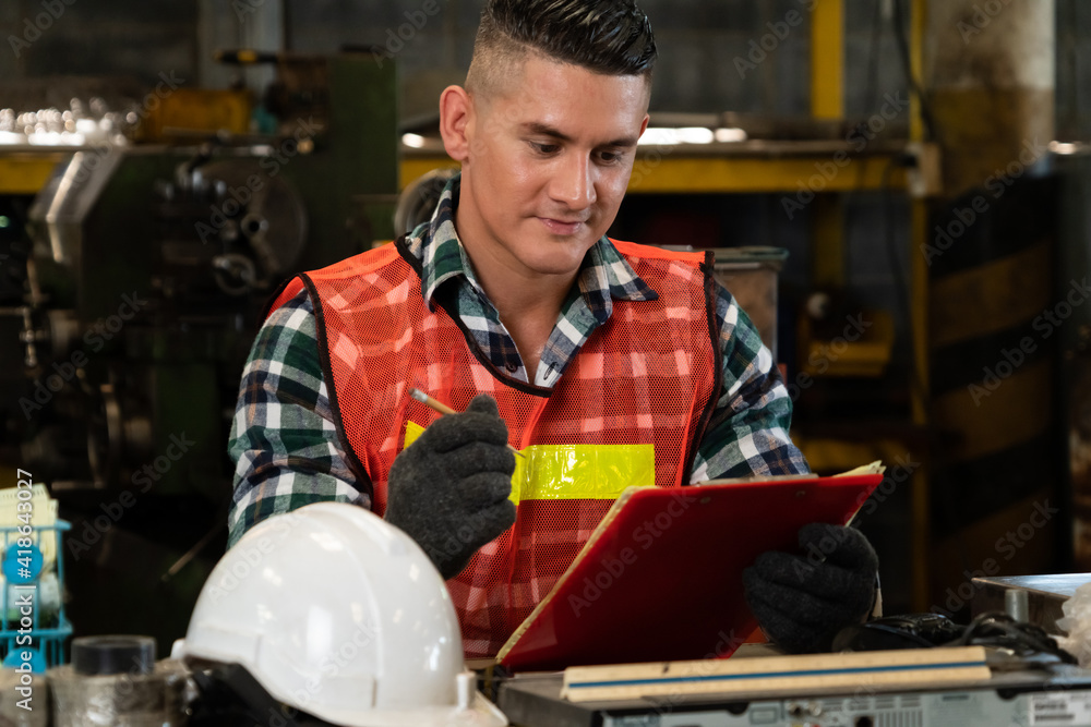 Poster manufacturing worker working with clipboard to do job procedure checklist . factory production line 