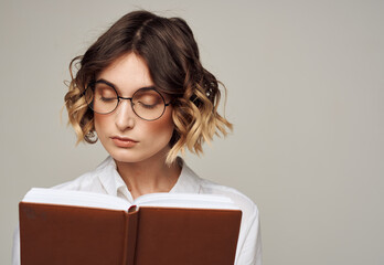 Woman with notepad in hands business finance glasses on her face