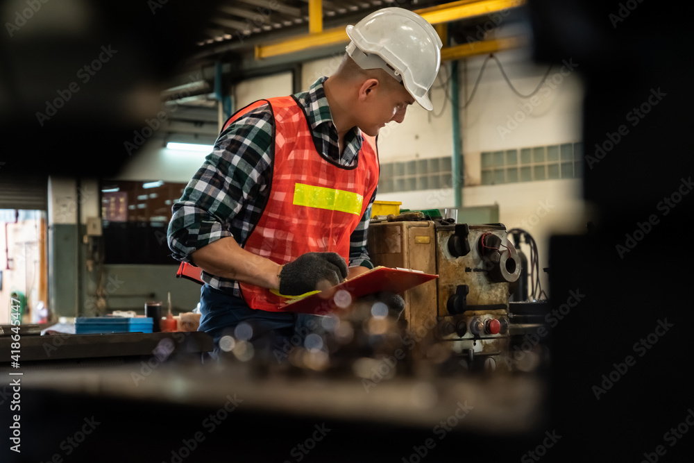 Poster manufacturing worker working with clipboard to do job procedure checklist . factory production line 