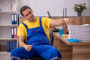 Obraz premium Young male contractor cleaning the office in industrial espionag