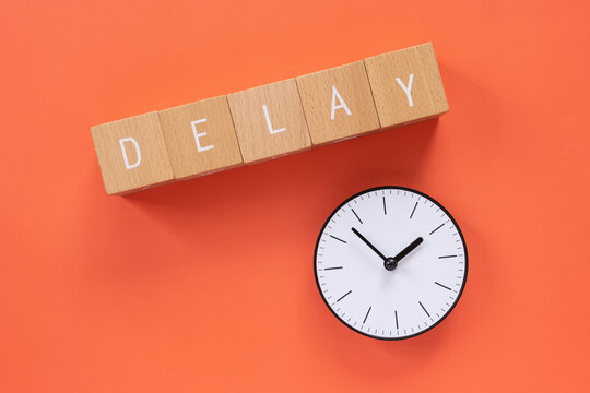 遅れ、遅延｜「DELAY」と書かれた積み木と時計