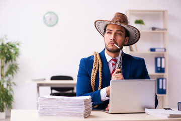 Young businessman cowboy working in the office - obrazy, fototapety, plakaty