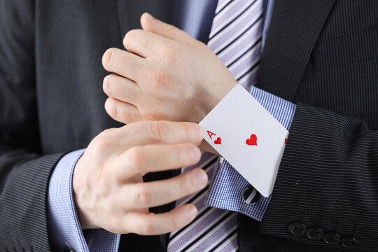 Businessman pulling ace out of his jacket pocket closeup. Confidence in victory concept