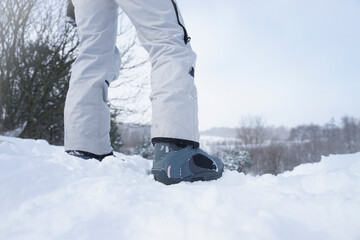 Snowboard boots. Snowboarder stands on a snowy mountain slope, boots close up