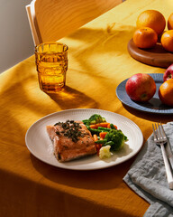 Bright food with salmon vegetables. Summer or spring sunny day or evening, table with bright yellow linen tablecloth, sunlight deep hard shadows from palms. Vibrant concept for healthy keto diet