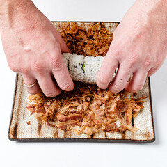 chef making japanese sushi on mat