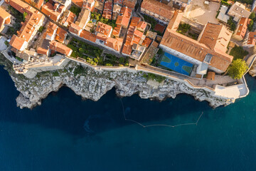 Aerial overhead drone shot of Dubrovnik City Wall by cliff and basketball field in Croatia summer morning © davidzzzfr