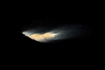 Dry river sand explosion.Brown color sand splash against black background.