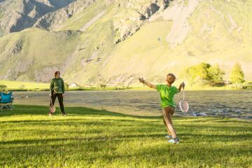 Obraz premium child and woman playing in badminton outdoors