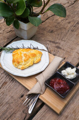 Homemade scone, strawberry jam and cream on a wooden table