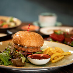 Fresh burger with grilled meat and French fries. Fast food menu concept. closev up shot. Nutritious snack or lunch. Classic American food. Square format for posting on social media.