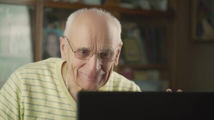 Senior man wearing eyeglasses has online video call with family during self isolation. Concept coronavirus and healthcare.