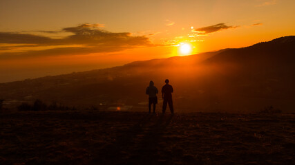 Fototapeta na wymiar Vista de puesta del sol con silueta de gente 