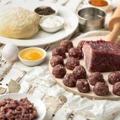 Process of cooking dumplings. meat balls and raw dough on wooden board. Ingredients and kitchen utensils to create delicious culinary masterpiece. Preparation of food. 