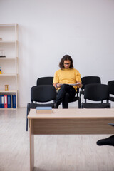 Fototapeta premium Young male student waiting for teacher in the classroom