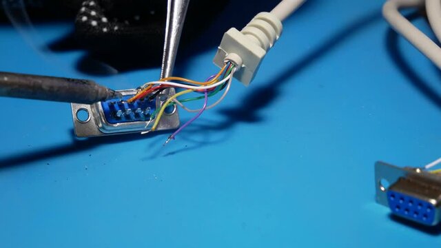 Engineer working soldering yellow wire to COM-port, repair man working process, stippling movements.