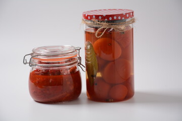 Jars of Homemade pickled vegetables: tomatoes, bell peppers on white background. Marinated and Fermented food. Fermented preserved vegetarian food concept.
