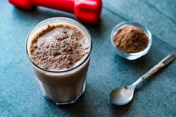 Fotobehang Chocolate Protein Shake Smoothie with Whey Protein Powder and Red Dumbbells. Sports Drink © Alp Aksoy