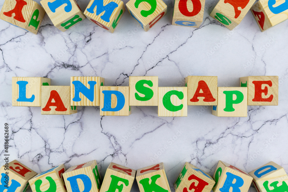 Fototapete landscape concept with colorful alphabet letters on wooden cubes centered between top and bottom bor