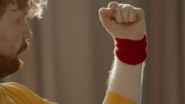 CARSH ZOOM Portrait of overweight Caucasian man puts on wristband at home. Bright, commercial high key advertising style lighting