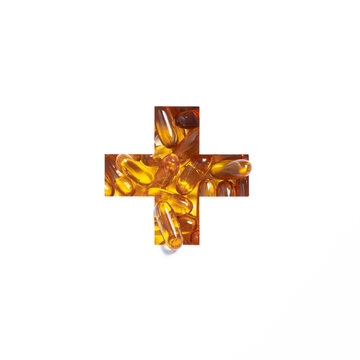 Plus summation sign or cross of omega capsules and cut paper isolated on white. Typeface made of fish oil pills