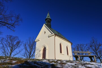 Fototapeta na wymiar Beautiful winter landscape with church. Sunny winter day. Brno - Lisen. Chapel of Our Lady of Helper.
