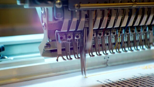 a working industrial embroidery machine applies a pattern to the fabric.close-up