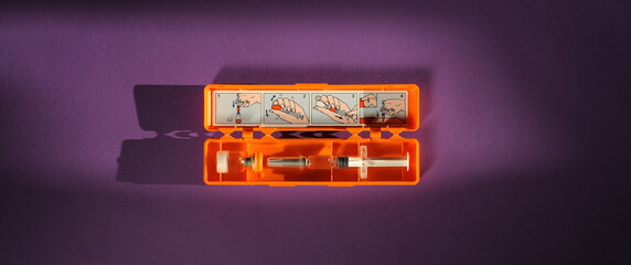 Syringe with glucagon on purple background. Diabetes. Diabetic coma. Hypoglycemia.