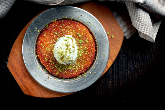 Appetizing Turkish sweetness Kanafeh made with shredded filo pastry with honey, pistachios and white ice cream