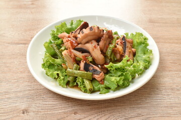 spicy stir fried squid with yard long bean and fresh vegetable on plate