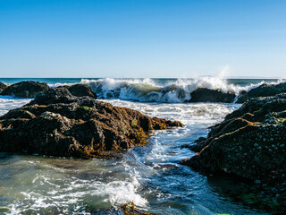 Waves and rocks in the intertidal zone at Tar Pits Beach in Carpinteria California on a sunny day.