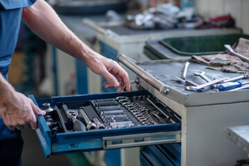 Male hands opening box with working tool