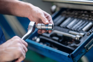 Male hands with auto repair tool