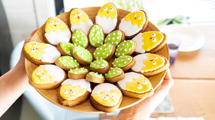 Easter gingerbread on a platter. Iceded cookies in the shape of cute chickens. Fun ideas for family baking together with children for Easter.