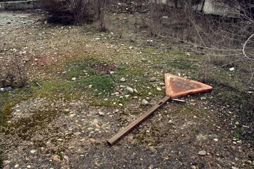 Señal de tráfico de ceda el paso. Señal de tráfico arrojada y abandonada entre los escombros de...