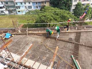 KUALA LUMPUR, MALAYSIA -MARCH 21, 2020: Building floor slab under construction. Construction workers fabricating the timber formwork and installing the steel reinforcement bar. 
