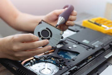 Close up of laptop computer hardware repairing or diagnostic with screwdriver. 