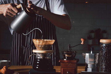 Coffee shop concept : Professional barista preparing coffee using chemex pour over coffee maker and...