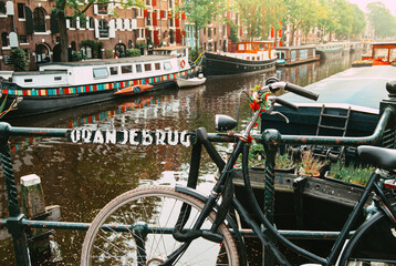Amsterdam, Holland, May 12 2018: Old bicycle parked on a canal bridge in Amsterdam