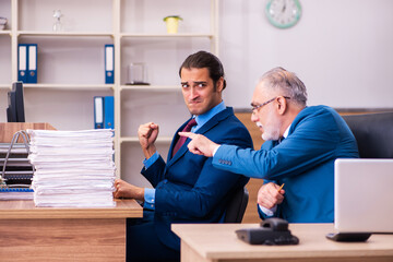 Obraz premium Old male boss and his young male assistant in bullying concept